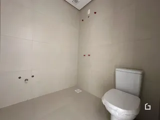 Foto de um banheiro interno com paredes brancas e um vaso sanitário.