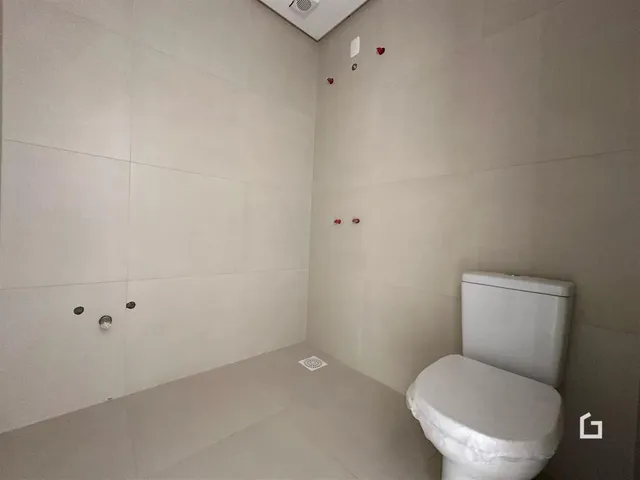 Foto de um banheiro interno com paredes brancas e um vaso sanitário.