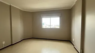 Ambiente interno de uma sala com paredes claras e piso de madeira.