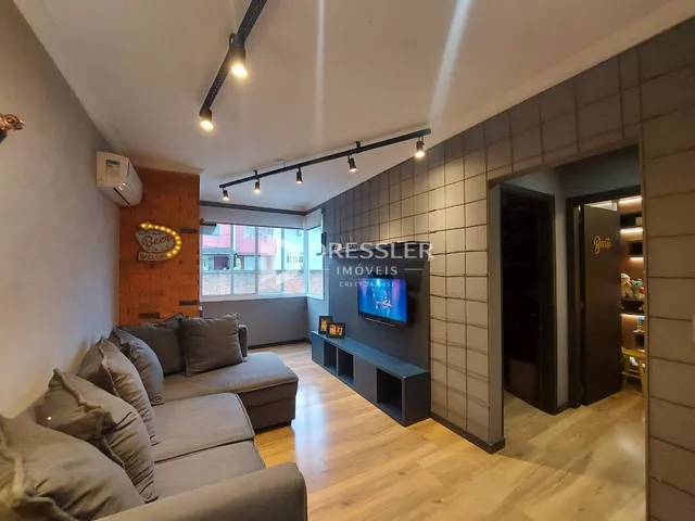 Sala de estar com sofá e piso de madeira clara.