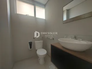 Foto de um banheiro interno com louças brancas e paredes claras.