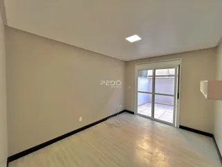 Vista interna de um ambiente com piso de madeira clara e paredes brancas.