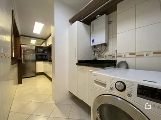 Cozinha com armários brancos e piso de cerâmica.