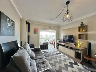 Sala de estar com sofá e painel de madeira na residência.