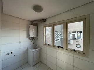 Banheiro com paredes revestidas de azulejos brancos.