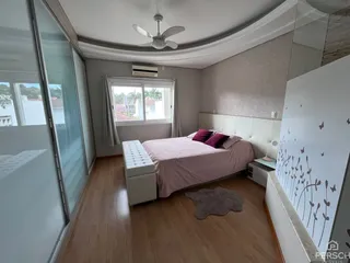 Quarto com cama e janela de vidro em um apartamento em Lajeado.