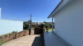 Fachada de uma residência em Lajeado, Brasil, com muro e portão de madeira.