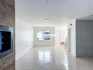 Ambiente interno amplo com piso claro e paredes brancas em um imóvel.