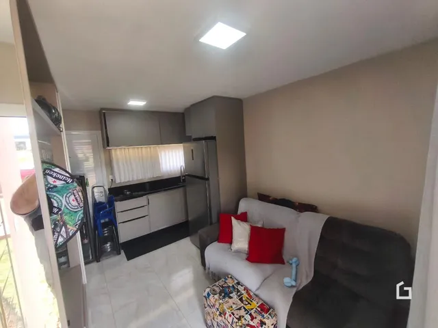 Sala de estar com cozinha integrada em imóvel no Brasil.