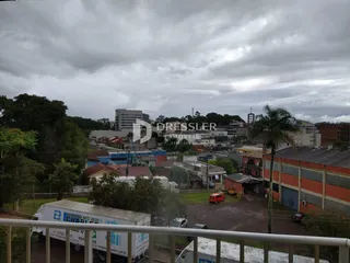 Vista externa de casas em Lajeado, Brasil, com vegetação ao redor.
