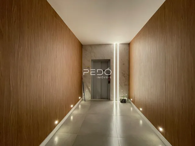 Corredor interno com paredes de madeira clara e piso cinza.