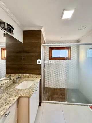 Foto de um banheiro com bancada de granito e box de vidro.