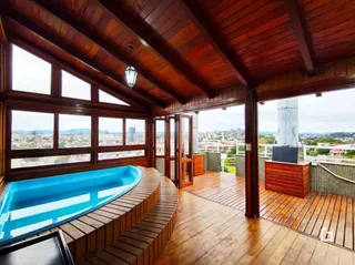 Vista de uma piscina e área externa de madeira com vista para a cidade em Lajeado.