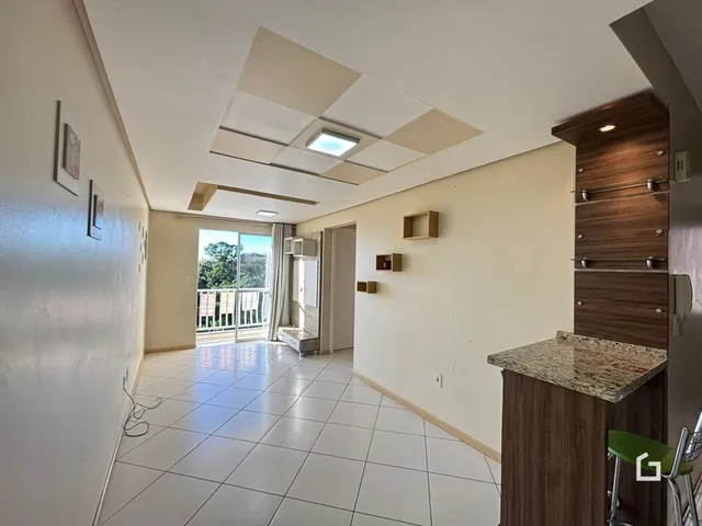 Hall de entrada com piso de cerâmica claro e teto de gesso branco.