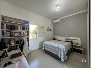 Quarto com cama e estante em um apartamento no Brasil.