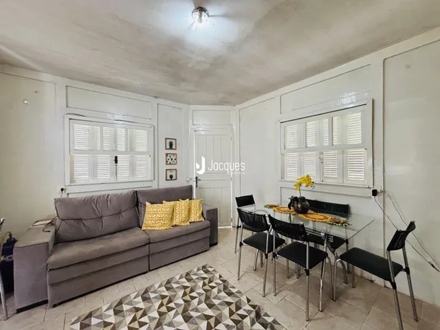 Sala de estar com sofá e mesa de jantar em um imóvel no Brasil.