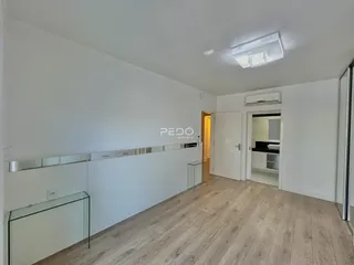 Ambiente interno com piso de madeira e revestimento de espelho.