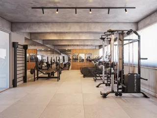 Vista de uma área comum com equipamentos de ginástica em um imóvel.