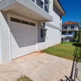 Fachada externa de uma casa branca em Lajeado, Brasil.