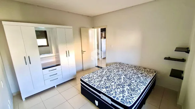 Quarto com armário branco e cama em um imóvel no Brasil.