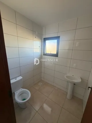 Foto de um banheiro interno com piso de cerâmica e louças sanitárias brancas.
