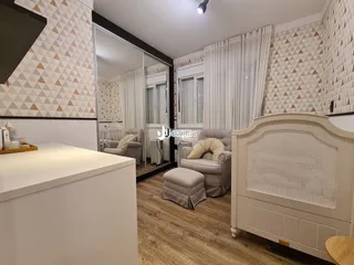 Ambiente interno de uma sala com decoração em tons neutros e piso de madeira.