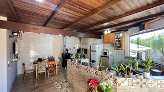 Interior de uma área comum com piso de madeira e teto de madeira em uma residência.