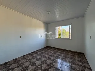 Foto de um ambiente interno com piso de ladrilhos marrons e paredes brancas.