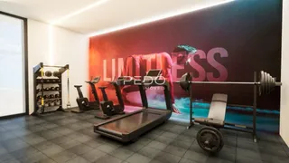 Interior de um espaço com equipamentos de ginástica e parede decorada.