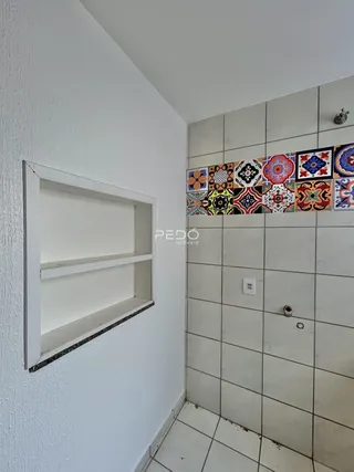 Vista de um canto interno com paredes brancas e revestimento de azulejos.