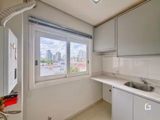 Vista interna de uma cozinha com janela para a cidade.