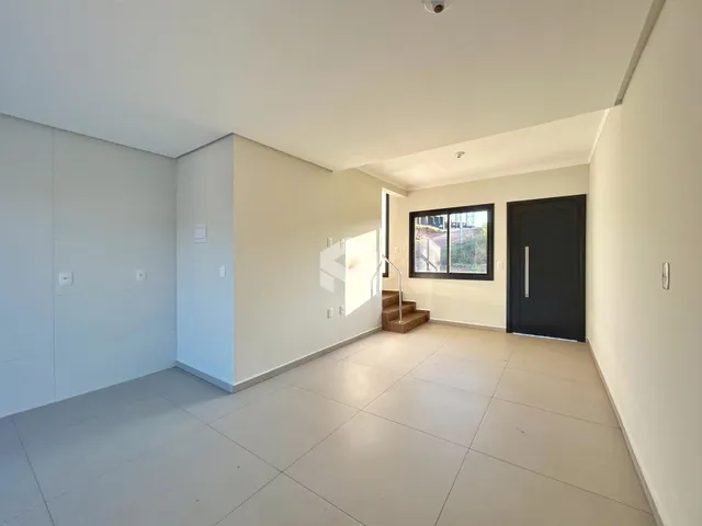 Vista interna de uma área ampla com piso de cerâmica e paredes brancas.