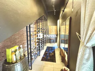 Hall de entrada com estantes de vinho e espelho decorativo.