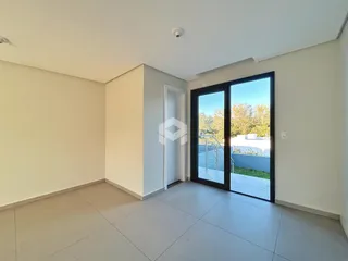 Ambiente interno com piso de cerâmica e porta de vidro abrindo para a área externa.