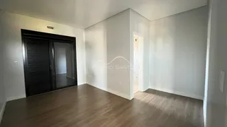 Ambiente interno com piso de madeira e paredes brancas.