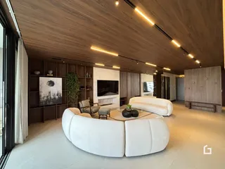 Sala de estar moderna com sofá curvo e parede de lareira em Lajeado.