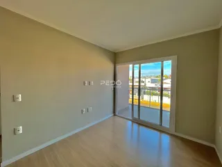 Ambiente interno com piso de madeira e porta de vidro que dá para o exterior.