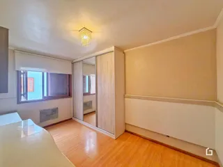 Sala de estar com piso de madeira e armários embutidos.