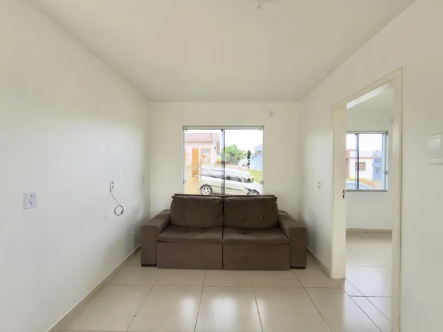 Sala de estar com sofá e porta de vidro.