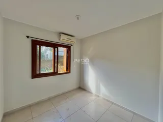 Sala de estar com piso de cerâmica e janela de madeira.
