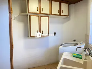 Foto de um ambiente interno com armários e máquina de lavar.