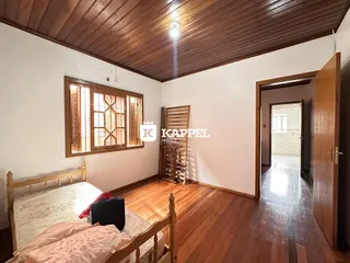 Quarto com cama de madeira e piso de madeira em um imóvel.