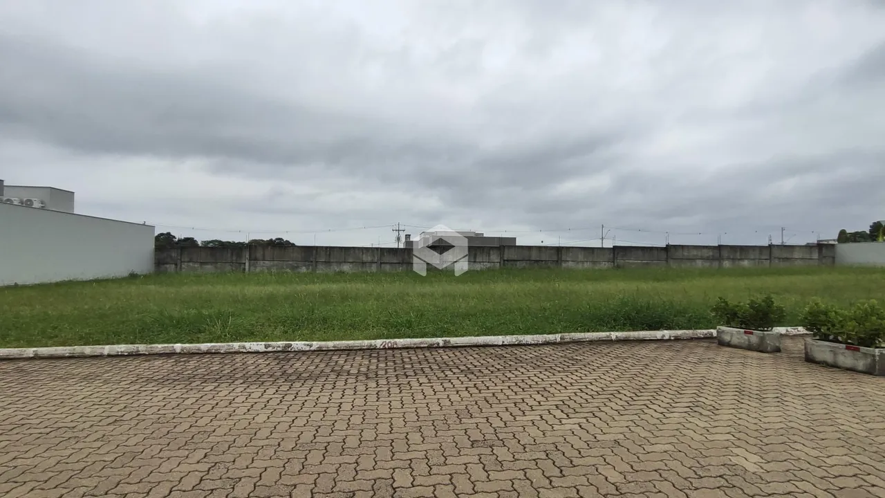 Vista externa de um terreno com muro e gramado verde.