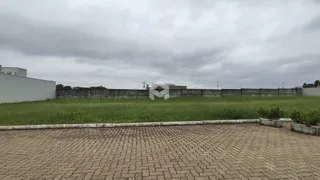 Vista externa de um terreno com muro e gramado verde.