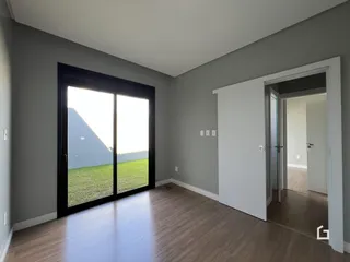 Uma sala de estar com porta de vidro que dá para um gramado.