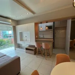 Sala de estar com paredes claras e iluminação interna.