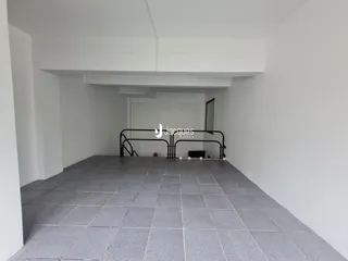 Vista de um corredor interno com piso de cerâmica cinza.