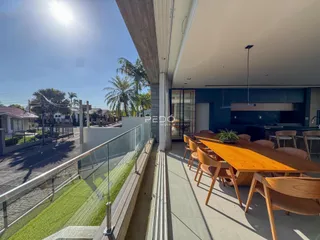 Vista de uma varanda com mesa de jantar em uma residência.
