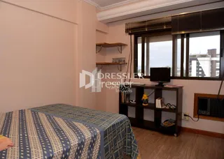 Quarto com cama e paredes brancas em um imóvel.