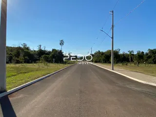 Uma estrada asfaltada se estende por uma propriedade com gramado verde.
